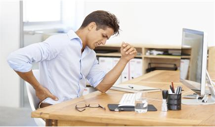 image of person sitting at computer desk and stretching